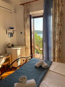 sypialnia z łóżkiem i oknem z widokiem w obiekcie Apartments Vila Miranda w mieście Barbat na Rabu
