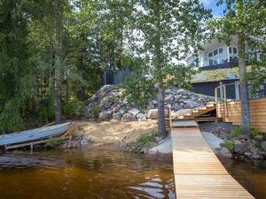a house with a dock and a boat on the water at Holiday Home Vapunkärki by Interhome in Orivesi