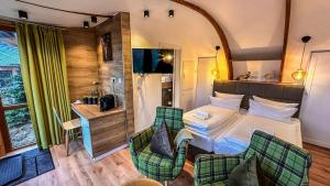ein Hotelzimmer mit einem Bett und zwei Stühlen in der Unterkunft Sonnenresort Ettershaus in Bad Harzburg