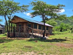 una casa en medio de un campo en kubwa mara safari lodge tent camp en Sekenani
