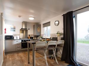 a kitchen with a table and chairs in a room at Chalet Wheal Amelia Lodge by Interhome in Helston