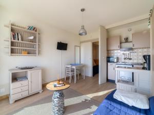 Una sala de estar con una mesa y una cocina. en Studio Ormarine by Interhome, en Le Lavandou