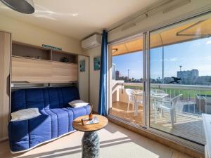 Una sala de estar con un sofá y un balcón. en Studio Ormarine by Interhome, en Le Lavandou