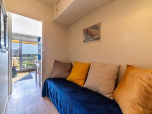 Una sala de estar con un sofá azul y una ventana. en Studio Ormarine by Interhome, en Le Lavandou 17 fotos más