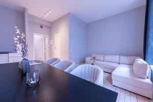 a living room with a table and chairs and a couch at Maya Apartments - Sentrum in Oslo