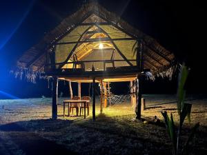 a tent with a chair and a hammock under it at Delft Jungle Beachfront Villa in Delft East