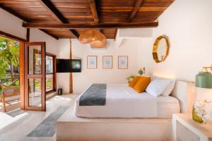 a bedroom with a large bed and a tv at Hotel Azulea Bacalar - Lagoon Front in Bacalar