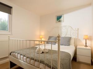 een slaapkamer met een wit bed en een raam bij Chalet Wheal Jewel Hot Tub Lodge by Interhome in Helston