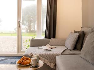 un soggiorno con divano e tavolo con pane di Chalet Wheal Jewel Hot Tub Lodge by Interhome a Helston