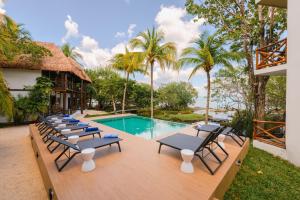 una fila di sedie a sdraio accanto alla piscina di Hotel Azulea Bacalar - Lagoon Front a Bacalar