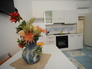 un vase avec des fleurs sur une table dans une cuisine dans l'établissement Apartment Mimì by Interhome, à Vietri