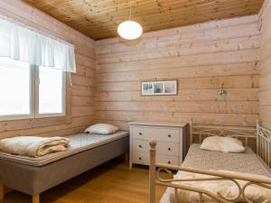 2 camas en una habitación con paredes de madera en Holiday Home Hongantaka by Interhome en Lamppi