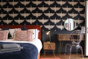 - une chambre avec un lit et un mur recouvert d'un papier peint à papillons dans l'établissement Rare Wood-Fired Hot Tub 2 Bed Get Away In Norfolk, à Norwich