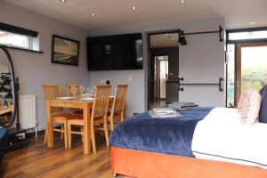 a bedroom with a bed and a table and chairs at Rare Wood-Fired Hot Tub 2 Bed Get Away In Norfolk in Norwich