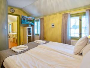 a bedroom with a large bed with two towels on it at Holiday Home Kartanohuoneisto pekka by Interhome in Runni