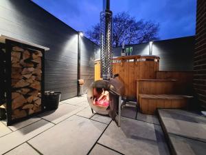a child sitting in a swing in front of a fireplace at Rare Wood-Fired Hot Tub 2 Bed Get Away In Norfolk in Norwich