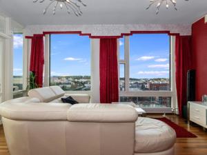 uma sala de estar com um sofá branco e janelas grandes em Holiday Home Horisontti penthouse by Interhome em Jyväskylä