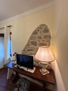 a desk with a television and a lamp on it at La Casina nel Borgo in Perugia