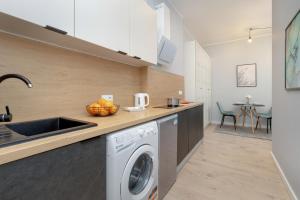 a kitchen with a washing machine and a sink at Cosy Studios near the Old Town in Gdańsk by Renters in Gdańsk