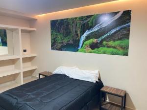 a bedroom with a bed with a painting on the wall at DESCANSO JUJEÑO in San Antonio