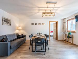 sala de estar con sofá, mesa y sillas en Apartment I tre Corvi by Interhome, en Prali