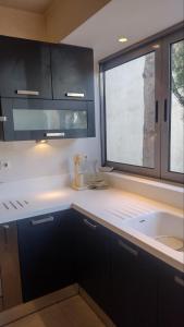a kitchen with a sink and a window at ΒΙΛΑ ΜΕ ΠΙΣΙΝΑ ΣΤΗΝ ΠΑΙΑΝΙΑ in Paianía