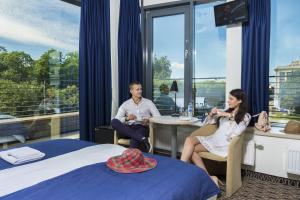 a man and a woman sitting in a hotel room at Kaunas City in Kaunas