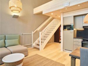 a living room with a couch and a staircase at Holiday Home Honka a by Interhome in Napapiiri