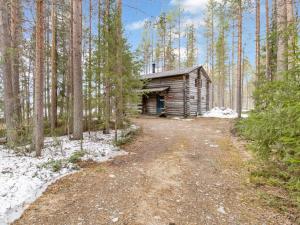 eine Blockhütte inmitten eines Waldes in der Unterkunft Holiday Home Keloaitta by Interhome 