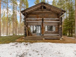 eine Blockhütte im Wald mit Bäumen in der Unterkunft Holiday Home Keloaitta by Interhome 