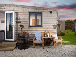 a tiny house with a table and chairs and a barrel at Chalet Wheal Prosper Hot Tub Lodge by Interhome in Helston
