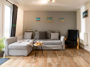 a living room with a couch and a table at Chalet Wheal Prosper Hot Tub Lodge by Interhome in Helston