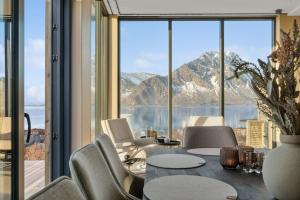 a dining room with a table and chairs and a large window at Fjordview Arctic Lodge in Lyngværet