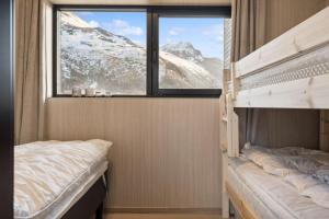 1 dormitorio con 2 literas y ventana en Fjordview Arctic Lodge, en Lyngværet