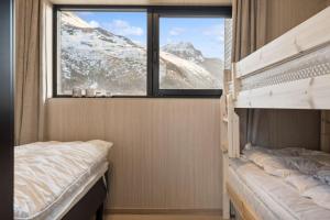 a bedroom with two bunk beds and a window at Fjordview Arctic Lodge with sauna and Jacuzzi in Lyngværet