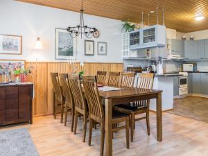 eine Küche und ein Esszimmer mit einem Holztisch und Stühlen in der Unterkunft Holiday Home Karhuportti by Interhome in Vuokatti