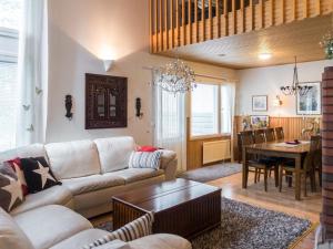 ein Wohnzimmer mit einem Sofa und einem Tisch in der Unterkunft Holiday Home Karhuportti by Interhome in Vuokatti