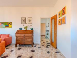 a living room with a wooden dresser and a orange chair at Apartment Il Pomelo by Interhome in Germignaga