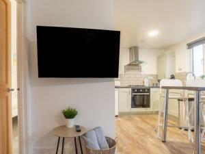 a tv hanging on a wall in a kitchen at Chalet Wheal Tor Lodge by Interhome in Helston