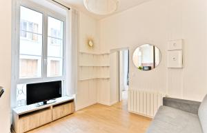 a living room with a tv and a window at Appartement au coeur du Marais in Paris