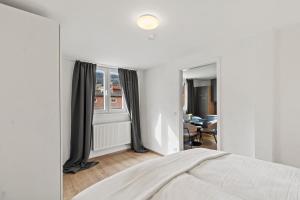 a white bedroom with a bed and a window at StayEasy Apartments Leoben P88 #12 in Donawitz