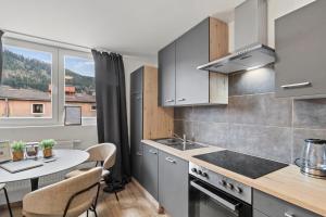 a kitchen with a table and a dining room at StayEasy Apartments Leoben P88 #12 in Donawitz