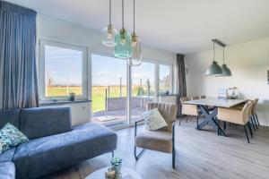 a living room with a blue couch and a table at Nieuwlanderweg 75 in De Waal