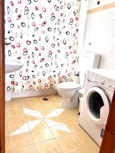 a bathroom with a washing machine and a shower curtain at Orfanos Houses No2 in Koroni