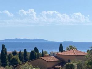 - une vue sur l'océan avec ses maisons et ses arbres dans l'établissement Villa Villa Vallon d'Aiguebelle by Interhome, au Lavandou