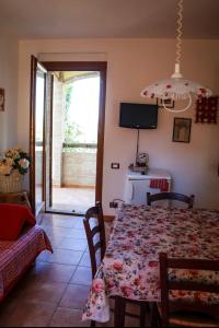 a dining room with a table and a view of a patio at Madonna Del Poggio CAV in Scarlino