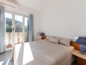 ein weißes Schlafzimmer mit einem Bett und einem Fenster in der Unterkunft Apartment I Boboli-1 by Interhome in Punta Ala