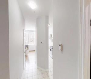 a hallway with white walls and a white kitchen at Bright Cozy Condo The Heart of Uptown 2BED Coffee & tea in Saint John