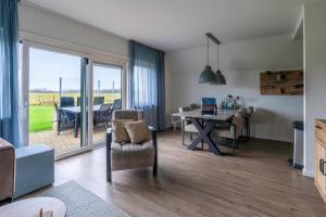 a living room with a table and chairs and a dining room at Nieuwlanderweg 77 in De Waal