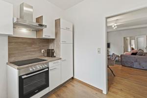 a kitchen with a stove top oven next to a living room at StayEasy Apartments Mautern #11 in Mautern in Steiermark